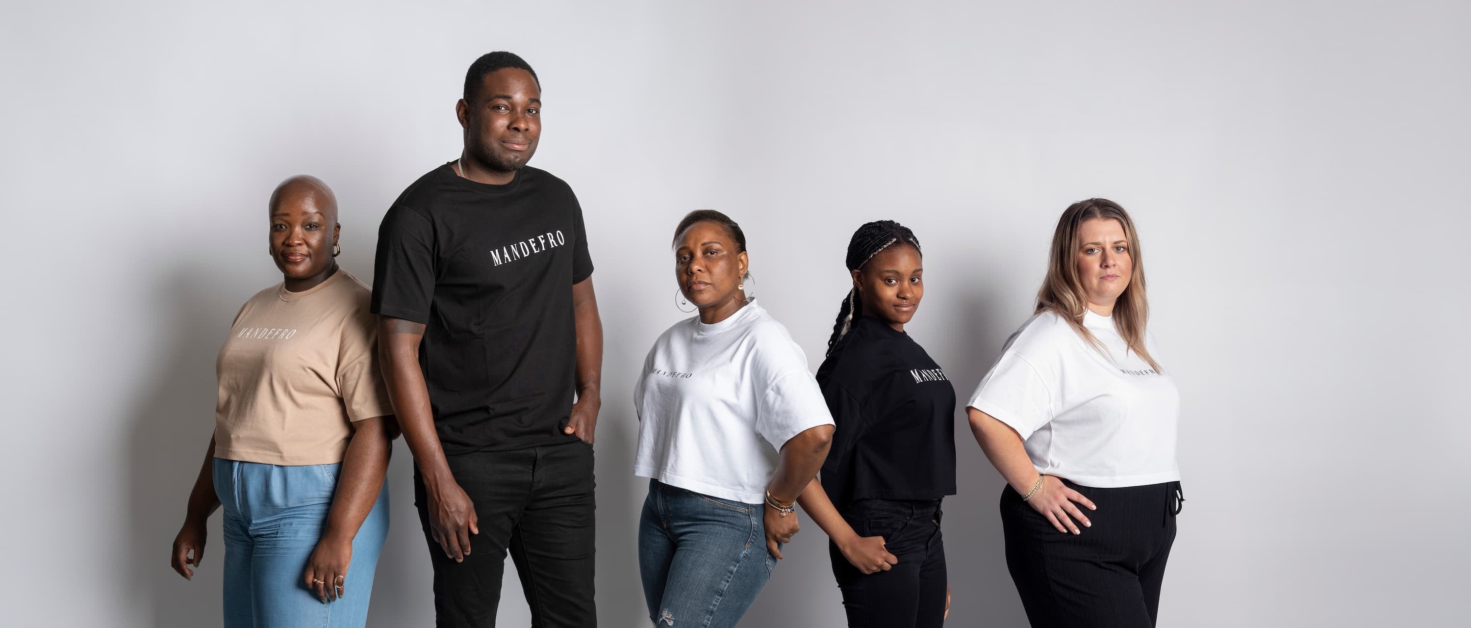 Five people standing side by side against a white background, wearing branded 'MANDEFRO' t-shirts.