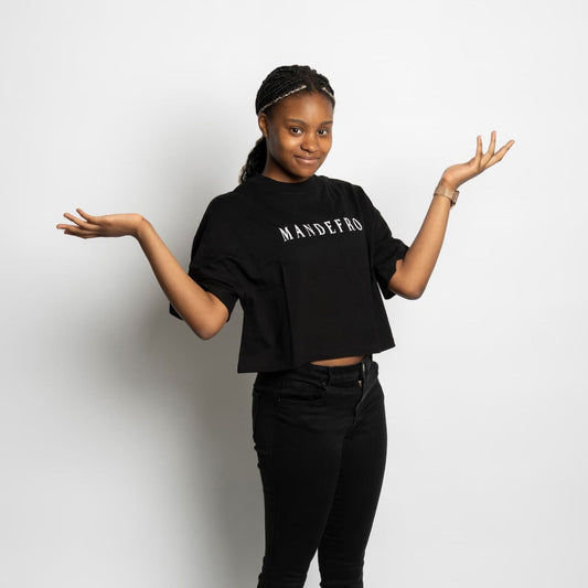 Girl wearing a black cropped t-shirt with 'MANDEFRO' text in front of a white backdrop