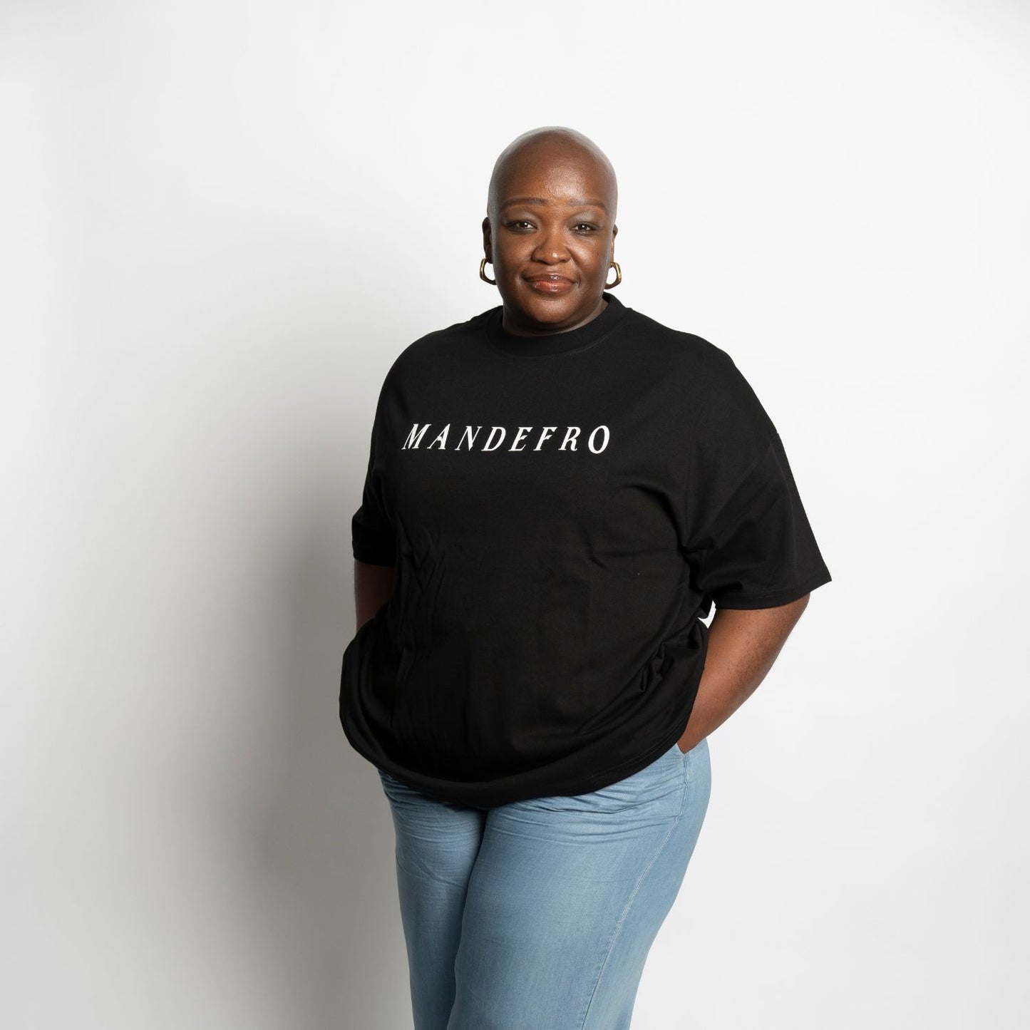 Woman wearing a black t-shirt with 'MANDEFRO' text on a white background